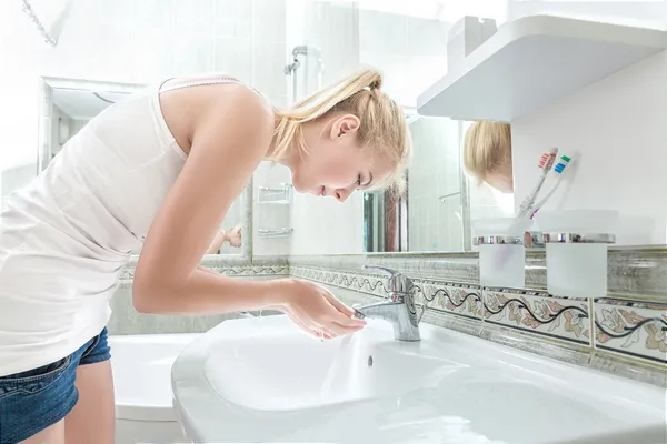 Mujer joven lavándose la cara — Foto de Stock