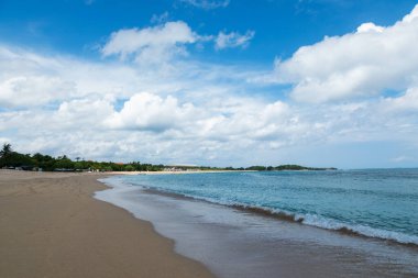Tropik bir manzara. Köpüklü yüksek dalgalar kıyıya yayıldı. Nusa dua Sahili, Bali Adası, Endonezya. Güzel yaz manzaralı okyanus beyaz kumsalda.
