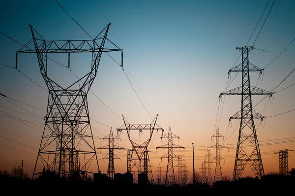 Torri di trasmissione elettrica (tralicci elettrici) al tramonto — Foto Stock