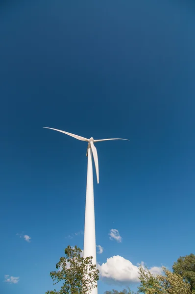 Großes Windrad mit Bäumen und blauem Himmel — Stockfoto