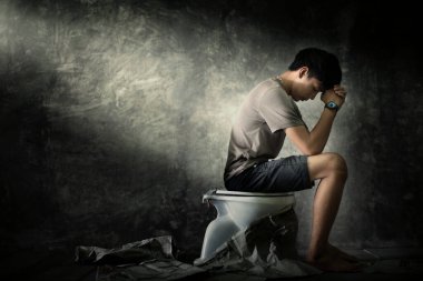 Karanlık bir köşede oturan bir adam düşüncelere dalmış ve endişeli. depresyon kavramı
