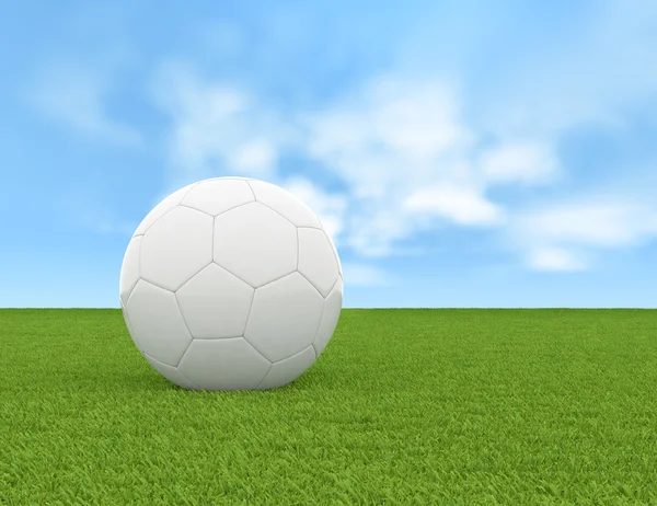 Soccer ball on green grass and blue sky background — Stock Photo, Image