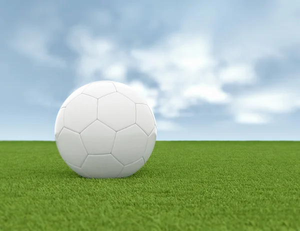 Soccer ball on green grass and blue sky background — Stock Photo, Image