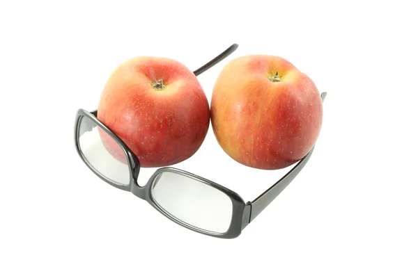 Ojo gafas frente a dos manzanas sobre fondo blanco . — Foto de Stock