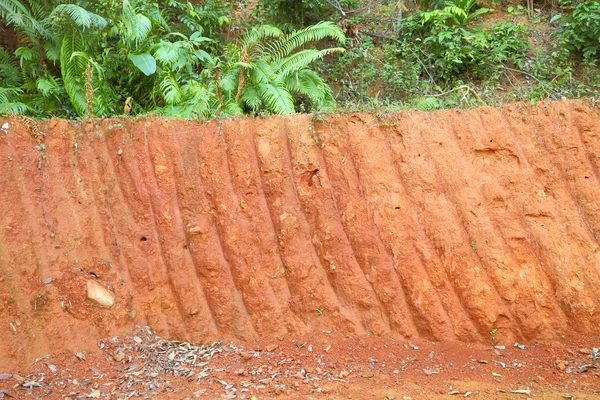 Горизонтальна червона скеля невеликого рівня земля копає колодязь . — стокове фото