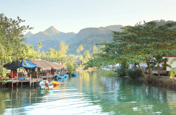 Tropisches Fischerhaus Dorfbewohner Kanal und ein Boot in der Nähe von Berg. — Stockfoto