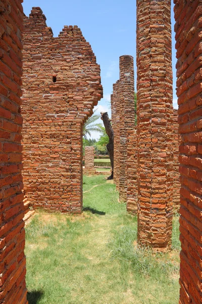 Ancient way with crack brick pole in history park.