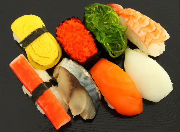 Несколько видов суши на черной тарелке . — стоковое фото