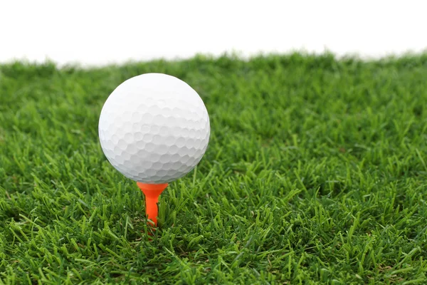 高尔夫球在球棒上塑料三通在绿草中. — 图库照片