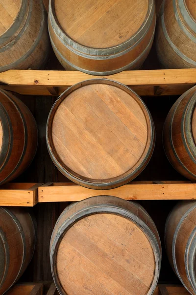 Vertical wooden wine barrels in cellar shelf. — Stock Photo, Image