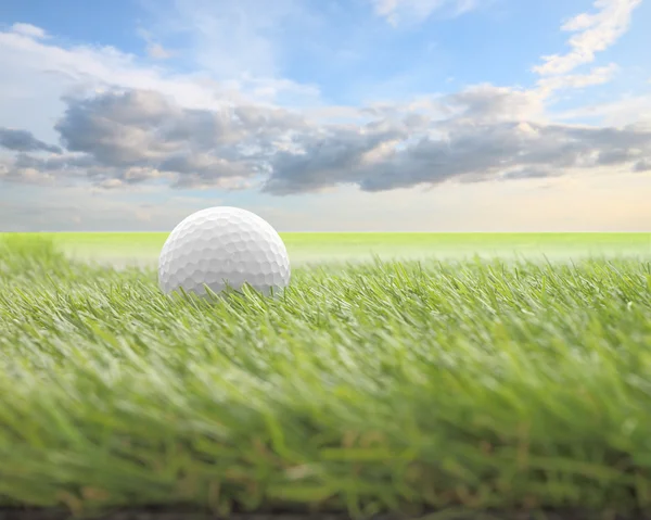 Golf topu bulanıklık bulut sabah gökyüzünde yeşil cephesinde.