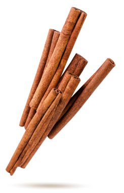 Tarçın çubukları beyaz bir zemine yakın uçar. İzole edilmiş