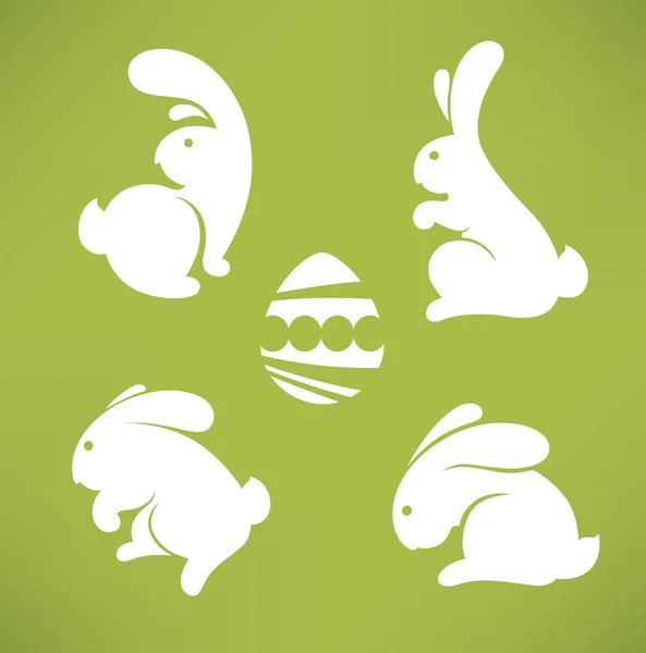 Bílé siluety velikonočních králíků na zeleném pozadí — Stockový vektor
