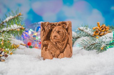 Karda Noel çikolatası oyuncağı. 2022 yılının sembolü olarak kaplan şeklinde çikolata oyuncağı. Neşeli ruh hali.