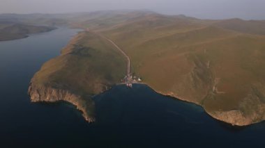 Gün doğumunda doğu kıyısından Olkhon Adası 'na giden bir feribot. Baykal Gölü. Adanın diğer tarafından..