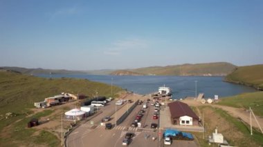 Gün doğumunda doğu kıyısından Olkhon Adası 'na giden bir feribot. Baykal Gölü. Adanın diğer tarafından..
