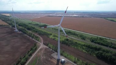 Rüzgar güç türbininin hava görüntüsü güzel bulutlu gökyüzünde popüler sürdürülebilir, yenilenebilir bir enerji kaynağıdır. Rüzgar güç türbinleri sürdürülebilir kalkınma için temiz yenilenebilir enerji üretiyor.