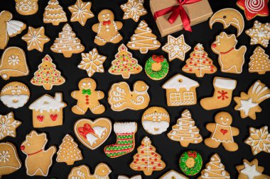 Koyu bir yüzeyde farklı şekillerde zencefilli kurabiye deseni. Üst görünüm.