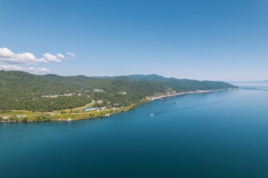 Baykal Gölü manzaralı dağlar ve ormanlar tarafından çerçevelenmiş olağanüstü mavi bir mücevherdir. Efsanevi sinematik hava manzaralı Baykal Gölü. Mavi göl ve yeşil ormanların havadan görünüşü.