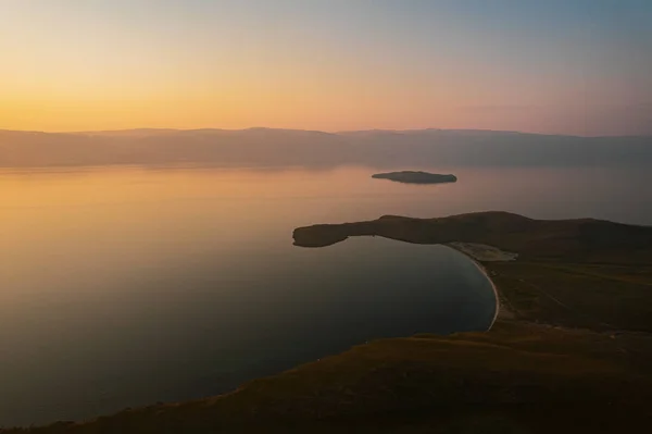 Wyspa Olkhon o wschodzie słońca, największa wyspa na Bajkał we wschodniej Syberii. Skała Shamanka na jeziorze Bajkał koło Khuzhiru na wyspie Olkhon na Syberii, Rosja. Obrazek Stockowy