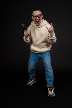 Genç mutlu iş adamı, siyah arka planda izole edilmiş bir yığın para rublesiyle dans ediyor. Nakit para tabancası. Seçici odak, ana konu - erkek.