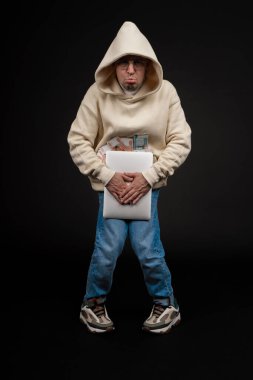 Defteri ve kara arka planda izole edilmiş bir yığın parası olan genç ve mutlu bir iş adamı. Seçici odaklanma, ana konu - adam. İlginç bir iş konsepti.