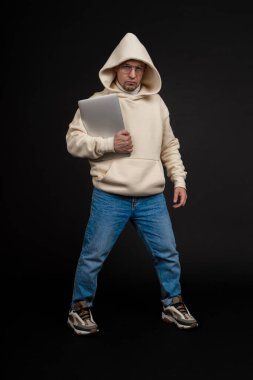 Siyah arka planda not defteri olan mutlu genç bir iş adamı. Seçici odaklanma, ana konu - adam. İlginç bir iş konsepti.