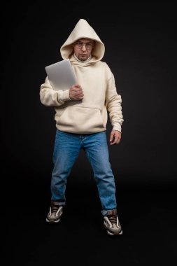 Siyah arka planda not defteri olan mutlu genç bir iş adamı. Seçici odaklanma, ana konu - adam. İlginç bir iş konsepti.