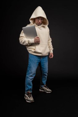 Siyah arka planda not defteri olan mutlu genç bir iş adamı. Seçici odaklanma, ana konu - adam. İlginç bir iş konsepti.