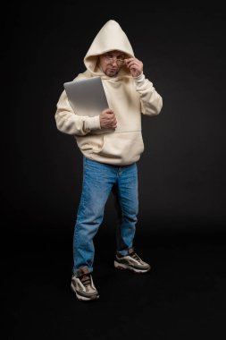 Siyah arka planda not defteri olan mutlu genç bir iş adamı. Seçici odaklanma, ana konu - adam. İlginç bir iş konsepti.