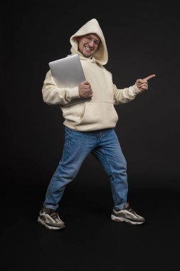 Siyah arka planda not defteri olan mutlu genç bir iş adamı. Seçici odaklanma, ana konu - adam. İlginç bir iş konsepti.