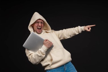 Siyah arka planda not defteri olan mutlu genç bir iş adamı. Seçici odaklanma, ana konu - adam. İlginç bir iş konsepti.