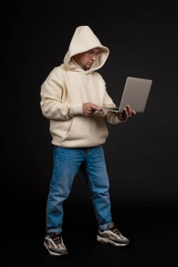 Siyah arka planda not defteri olan mutlu genç bir iş adamı. Seçici odaklanma, ana konu - adam. İlginç bir iş konsepti.