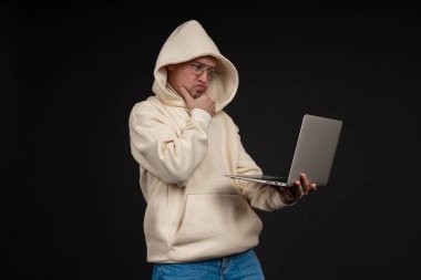 Siyah arka planda not defteri olan mutlu genç bir iş adamı. Seçici odaklanma, ana konu - adam. İlginç bir iş konsepti.