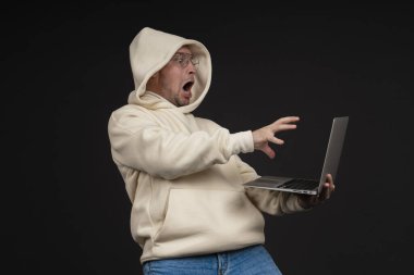 Siyah arka planda not defteri olan mutlu genç bir iş adamı. Seçici odaklanma, ana konu - adam. İlginç bir iş konsepti.