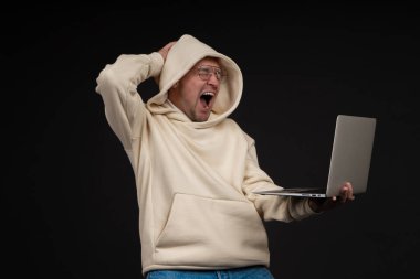 Siyah arka planda not defteri olan mutlu genç bir iş adamı. Seçici odaklanma, ana konu - adam. İlginç bir iş konsepti.