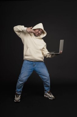 Siyah arka planda not defteri olan mutlu genç bir iş adamı. Seçici odaklanma, ana konu - adam. İlginç bir iş konsepti.