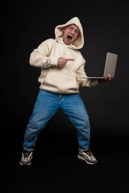 Siyah arka planda not defteri olan mutlu genç bir iş adamı. Seçici odaklanma, ana konu - adam. İlginç bir iş konsepti.