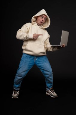 Siyah arka planda not defteri olan mutlu genç bir iş adamı. Seçici odaklanma, ana konu - adam. İlginç bir iş konsepti.