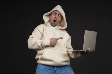 Siyah arka planda not defteri olan mutlu genç bir iş adamı. Seçici odaklanma, ana konu - adam. İlginç bir iş konsepti.