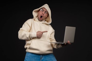 Siyah arka planda not defteri olan mutlu genç bir iş adamı. Seçici odaklanma, ana konu - adam. İlginç bir iş konsepti.