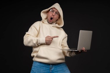 Siyah arka planda not defteri olan mutlu genç bir iş adamı. Seçici odaklanma, ana konu - adam. İlginç bir iş konsepti.