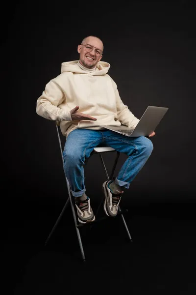 Joven hombre de negocios feliz con un cuaderno aislado sobre fondo negro. Enfoque selectivo, sujeto principal - hombre. Interesante concepto de negocio. —  Fotos de Stock