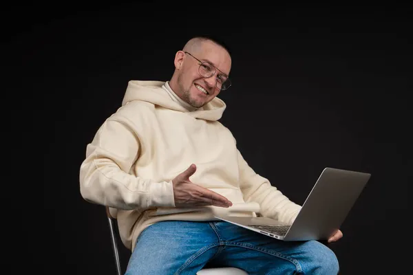 Young happy businessman with a notebook isolated on black background. Selective focus, main subject - man. Interesting business concept. — Stock Photo, Image