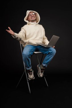 Siyah arka planda not defteri olan mutlu genç bir iş adamı. Seçici odaklanma, ana konu - adam. İlginç bir iş konsepti.