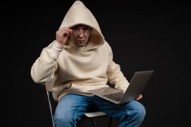 Siyah arka planda not defteri olan mutlu genç bir iş adamı. Seçici odaklanma, ana konu - adam. İlginç bir iş konsepti.