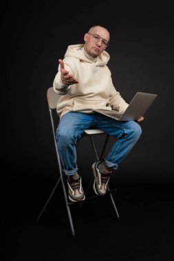 Siyah arka planda not defteri olan mutlu genç bir iş adamı. Seçici odaklanma, ana konu - adam. İlginç bir iş konsepti.