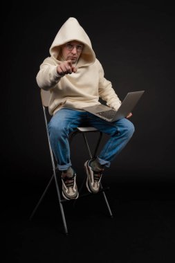 Siyah arka planda not defteri olan mutlu genç bir iş adamı. Seçici odaklanma, ana konu - adam. İlginç bir iş konsepti.