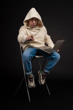 Siyah arka planda not defteri olan mutlu genç bir iş adamı. Seçici odaklanma, ana konu - adam. İlginç bir iş konsepti.