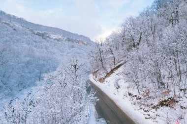 Kışın Lago-Naki Dağları 'nın uçan manzarası ve araba sürüşü. Destansı, karlı beyaz kış ve karlı orman.